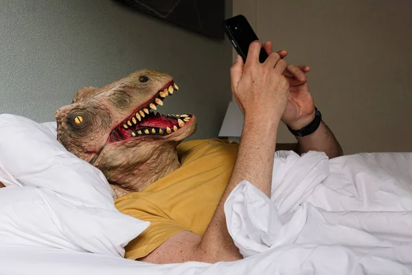 Hombre Con Máscara Lagarto Usando Teléfono Inteligente Una Cama Hotel —  Fotos de Stock