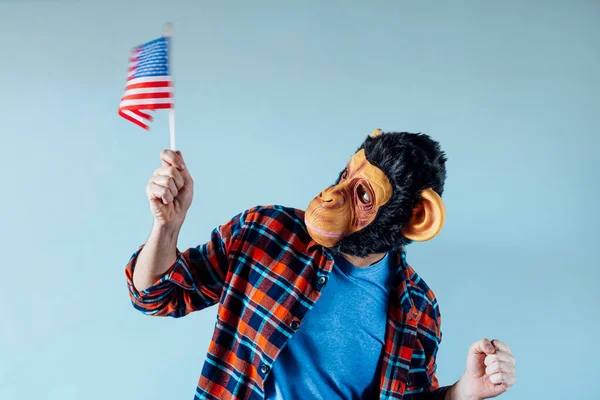 Man with a monkey mask and a flag of the United States of America.