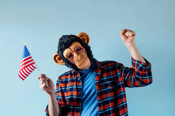 Man with a monkey mask and a flag of the United States of America.