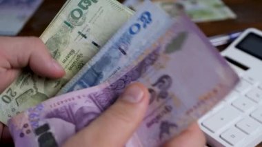 İşadamlarının elleri baht banknotlarını sayar