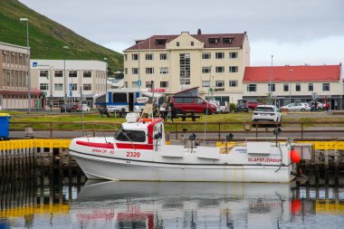 Siglufjordur, İzlanda - 5 Ağustos. 2021: Siglufjordur limanındaki tekneler ve arka planda binalar