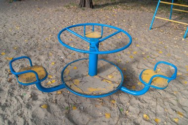 Empty children's carousel in the courtyard of the house in autumn. . The concept of childhood, growing.