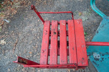 The old seat of an empty children's carousel in the courtyard of the house in autumn. The concept of childhood, growing up
