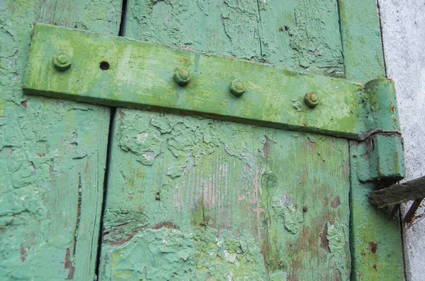 An old iron hinge on an old wooden door. Made of iron close-up on the background of a wooden door.