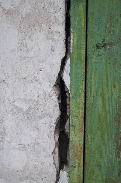 A crack formed between the brick wall of the barn and the fastening of the doors.