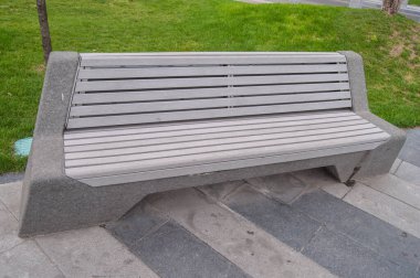 Bench with seat made of gray panels in a city park
