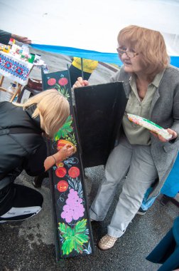 DNIPRO, UKRAINE - 10 Eylül 2022: Ukraynalı ustalar şehir meydanında tanksavar kirpilerini boyuyorlar.