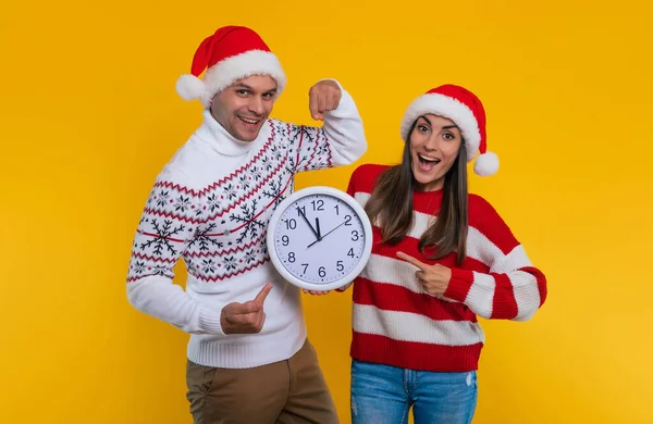 Divertida Pareja Joven Encantadora Navidad Sombreros Santa Celebración Reloj Grande — Foto de Stock
