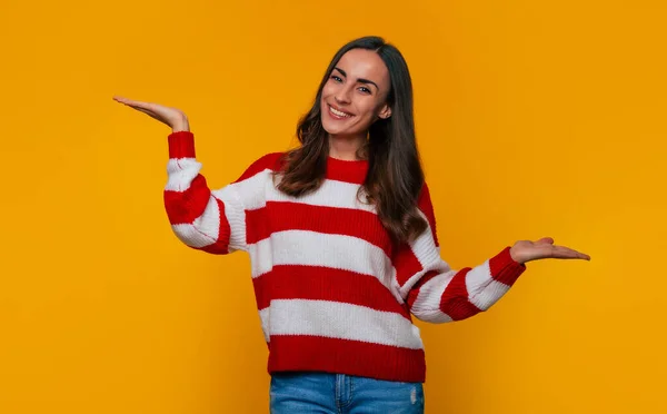 Portret Uroczej Szczęśliwej Brunetki Swetrze Która Pokazuje Coś Dłoniach Reklamy — Zdjęcie stockowe