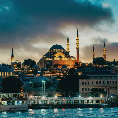 İstanbul, Türkiye - Eylül 2021: Süleyman Camii 'nde akşam saatlerinde ışıklar ve İstanbul' da dramatik bulutlar yükseliyor. Süleyman Camii Osmanlı döneminde Mimar Sinan tarafından inşa edilmiştir..