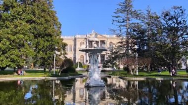 İstanbul, Türkiye - Aralık 2021: Dolmabahçe Sarayı ve bahçelerini ziyaret eden turistler. Dolmabahce Sarayı Osmanlı İmparatorluğu 'nun ana yönetim merkezi olarak hizmet verdi.