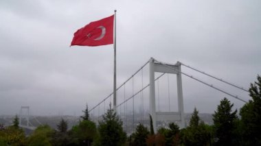 İstanbul Boğazı 'nı kaplayan Fatih Sultan Mehmet Köprüsü' nün Türk bayrağı. Türkiye bayrağı, resmi olarak Türk bayrağı, üzerinde beyaz yıldız ve hilal bulunan bir kırmızı bayrak..
