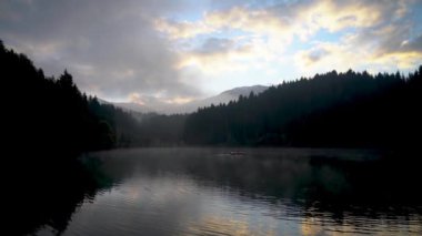 Artvin, Türkiye - Ekim 2021: Doğu Karadeniz 'deki Savsat Karagol Gölü' nde sabah buharlaşmasıyla kürek çeken adam. Savsat Karagol gölü, Artvin 'in Savsat ilindeki ormanda yer alan büyük bir alabalık gölüdür.