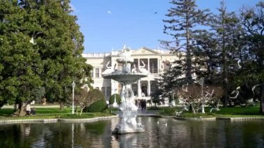 İstanbul, Türkiye - Aralık 2021: Dolmabahçe Sarayı ve bahçelerini ziyaret eden turistler. Dolmabahce Sarayı Osmanlı İmparatorluğu 'nun ana yönetim merkezi olarak hizmet verdi.