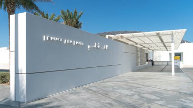 Abu Dabi, BAE - Şubat 2021: Louvre Abu Dabi Müzesi ana girişteki beyaz duvarda, Saadiyat Adası. Abu Dabi 'deki Louvre Müzesi yeni bir dönüm noktası.