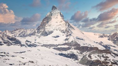 Mavi gökyüzü ve bulutlarla kaplı karlı Matterhorn tepesinin ikonik manzarası, Zermatt, İsviçre