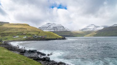 Kuzey Atlantik 'teki Faroe Adaları' nda küçük bir köyle dramatik bir manzara. Kuzey Atlantik 'teki Faroe Adaları' nın doğası.