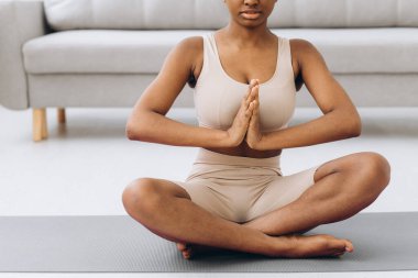 Genç siyahi kadın evde meditasyon yapıyor, yoga konsepti, boş alan.