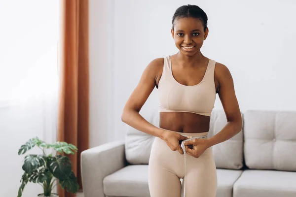 Mujer Negra Joven Mide Cintura Fondo Sala Estar Concepto Dieta — Foto de Stock