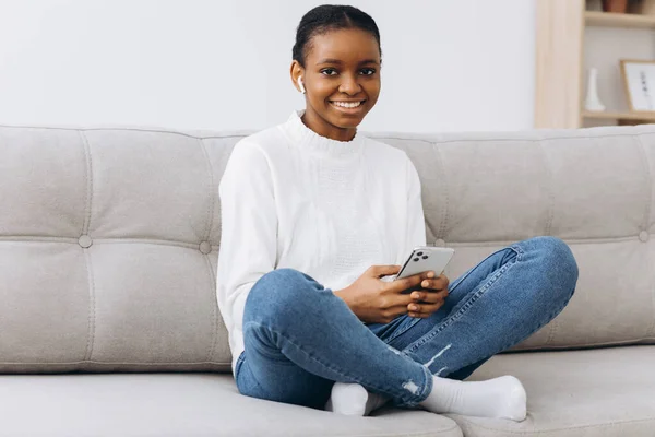 Sorrindo Mensagens Menina Preta Smartphone Casa Relaxando Sofá Confortável Desfrutando — Fotografia de Stock