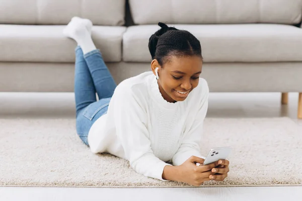 Sorrindo Mensagens Menina Preta Smartphone Casa Relaxando Sofá Confortável Desfrutando — Fotografia de Stock