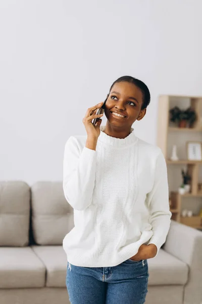 Leende Ung Svart Kvinna Pratar Telefon Vardagsrummet — Stockfoto