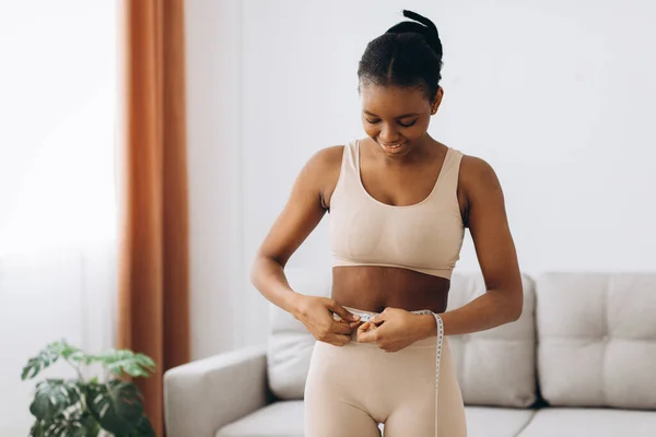 Mujer Negra Joven Mide Cintura Fondo Sala Estar Concepto Dieta — Foto de Stock
