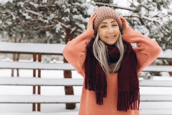 ニットのセーター スカーフ 帽子を着た灰色の髪のシニア女性冬の背景 — ストック写真