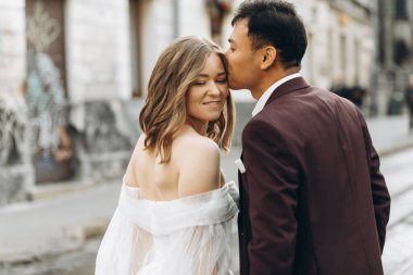 Uluslararası bir düğün çifti, Avrupalı bir gelin ve Asyalı bir damat şehirde birlikte dolaşıyorlar..