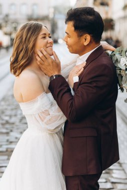 Uluslararası bir düğün çifti, Avrupalı bir gelin ve Asyalı bir damat şehirde birlikte dolaşıyorlar..