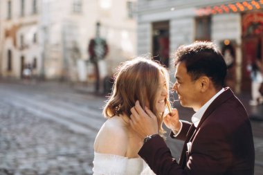 Uluslararası bir düğün çifti, Avrupalı bir gelin ve Asyalı bir damat şehirde birlikte dolaşıyorlar..