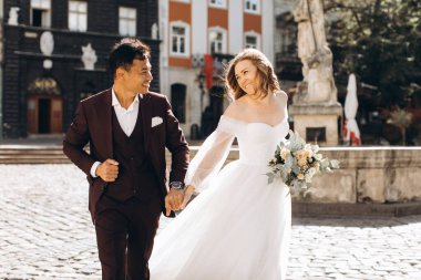 Uluslararası bir düğün çifti, Avrupalı bir gelin ve Asyalı bir damat şehirde birlikte dolaşıyorlar..