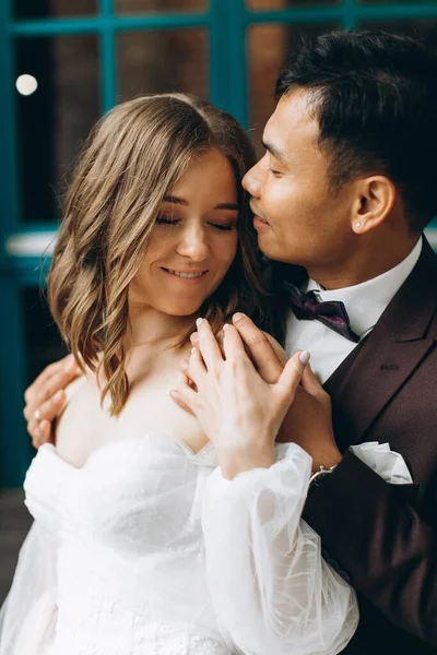 Dia Casamento Bela Noiva Europeia Seu Noivo Asiático Posando Contra — Fotografia de Stock