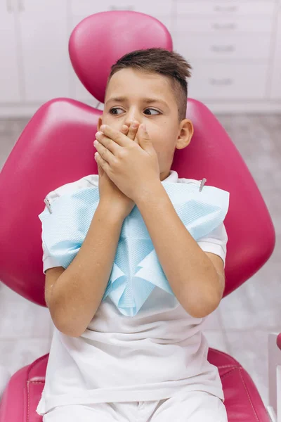 男の子は怖がっていて 歯医者の診療所の歯科医を訪問して手で口を閉じています — ストック写真