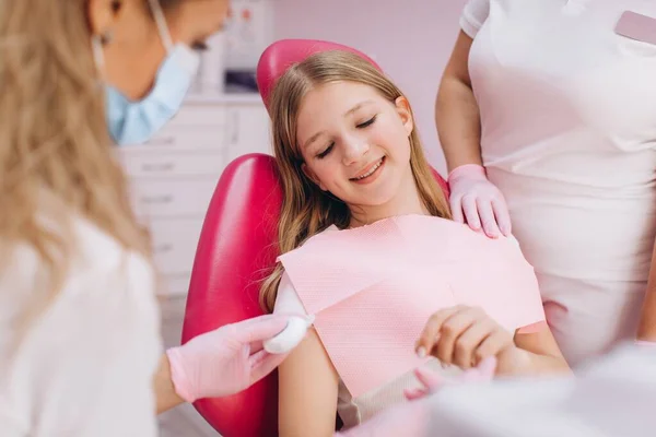 歯医者と彼女の助手は十代の女の子にフロスの方法を示す — ストック写真