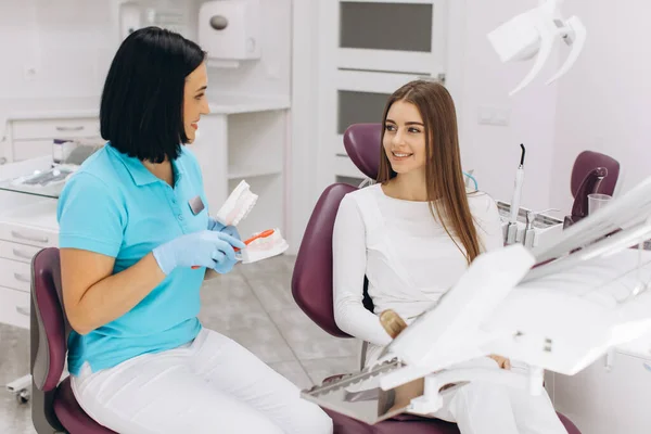 Женщина Дантист Показывает Пациентке Правильно Чистить Зубы — стоковое фото