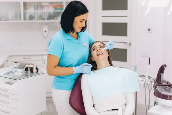 女牙医在牙椅上检查病人 — 图库照片