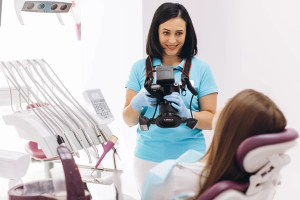 女牙医在牙科椅子上给病人的牙齿拍照 — 图库照片