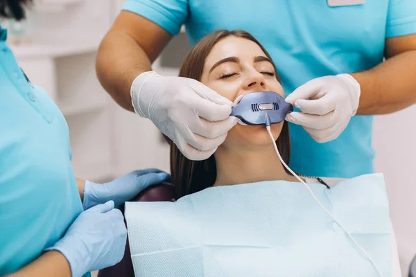 歯医者は歯のクリニックで紫外線歯を白くする — ストック写真