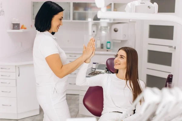 女牙医微笑着与她的病人握手致意 — 图库照片