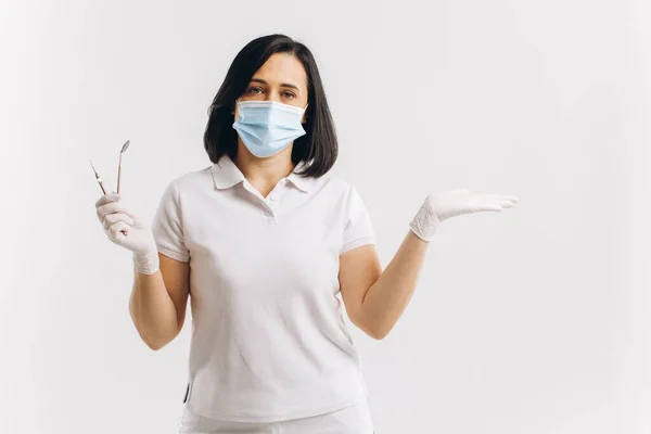 Mulher Dentista Uma Máscara Médica Mostra Algo Espaço Cópia — Fotografia de Stock