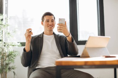 Modern gülümseyen ofis çalışanının ofiste bir video görüşmesi var.