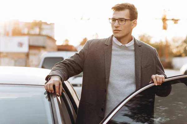 Yakışıklı Gözlüklü Genç Adam Dışarıda Dururken Arabasına Biniyor — Stok fotoğraf
