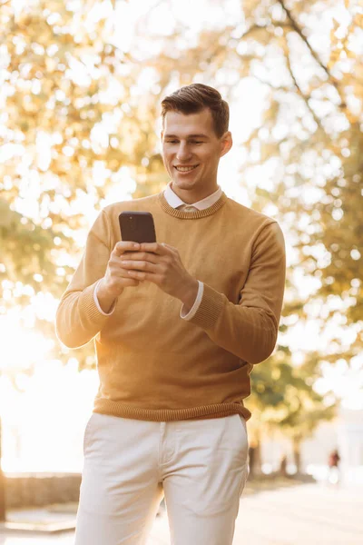 Sarı Beyaz Elbiseli Modern Yakışıklı Adam Gün Batımında Parkta Telefonla — Stok fotoğraf