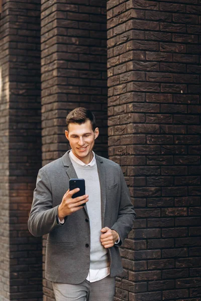 Moderní Pohledný Usměvavý Muž Kráčí Ulici Mluví Telefonu — Stock fotografie