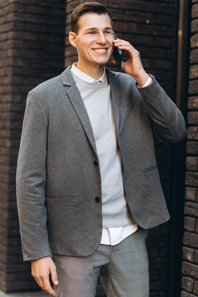 Modern Yakışıklı Gülümseyen Adam Sokakta Yürüyor Telefonla Konuşuyor — Stok fotoğraf
