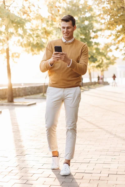 Moderní Pohledný Usmívající Muž Žlutých Bílých Šatech Mluví Telefonu Parku — Stock fotografie
