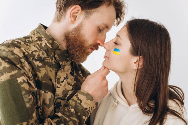 Ukrainian couple, military bearded man in uniform kisses his girlfriend at home