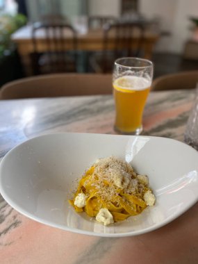 Restoranda birayla servis edilen krema soslu balkabaklı Tagliatelle. Vejetaryen ya da vejetaryen yemeği. Organik Gıda.