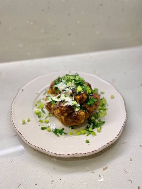 Baked Whole Vegan Cauliflower in Plate with Tahini Sauce, Molasses, Parsley and Chives. Tahin Pekmez. Ready to Serve and Eat.